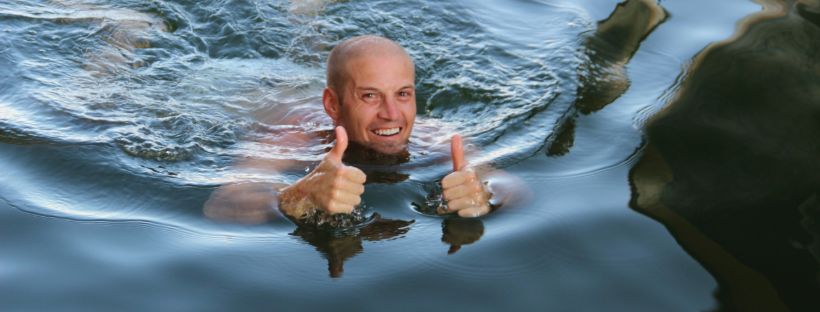Picture of a man swimming give the thumbs up signal with both hands for giving Swimming Lessons To Adults